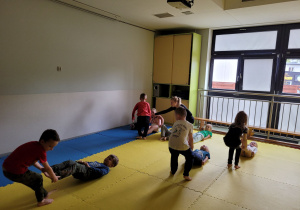 Dzieci wykonują zestaw ćwiczenie prezentowane przez trenerkę.