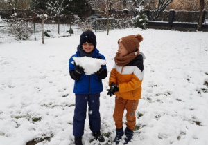 Bruno z Igorem lepią ogromną kulę śniegową.